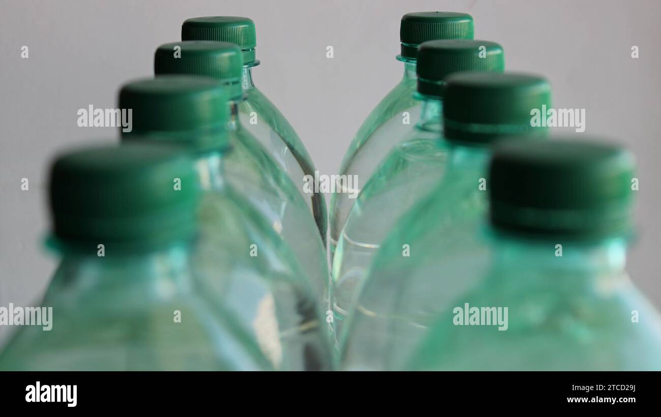 Two rows of plastic water bottles with focus on the last bottles isolated on white Stock Photo