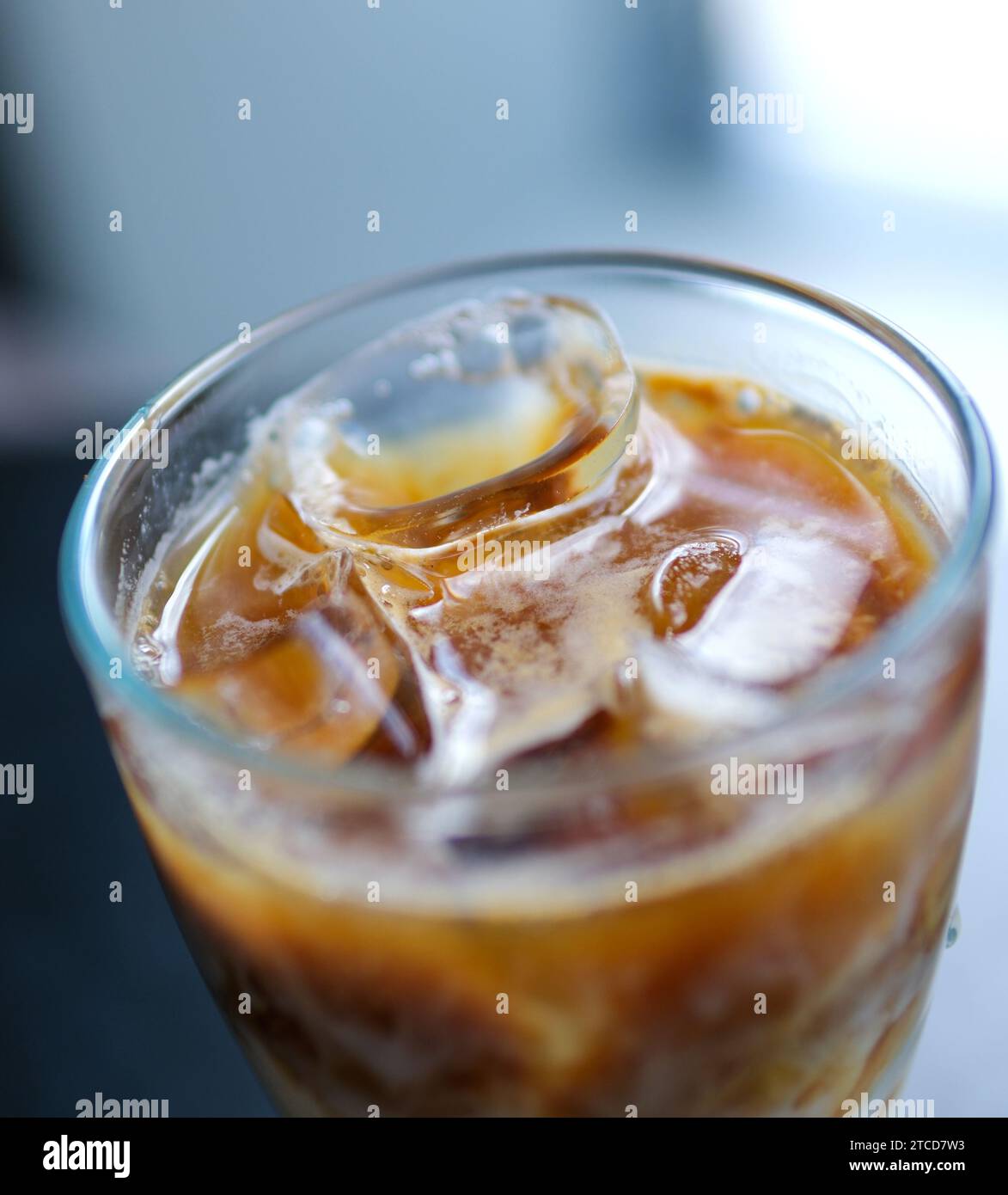 Es Teh. iced tea is a fresh drink made from tea, water, sugar, and ice cubes. iced tea in a clear glass on a brown wooden table. Indonesian drink. . High quality photo Stock Photo