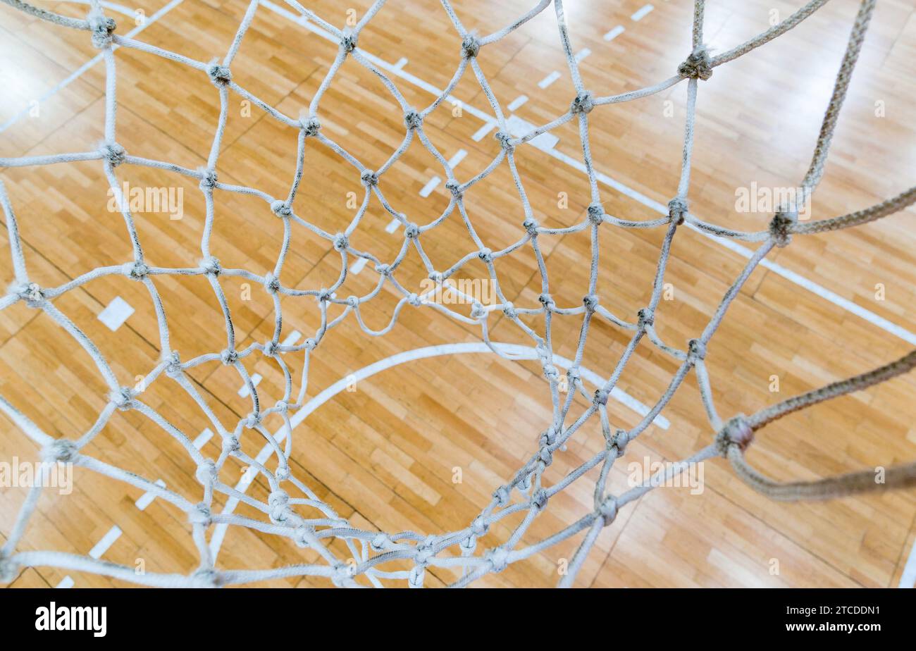 Top view of a parquet basketball court through the basketball hoop net Stock Photo