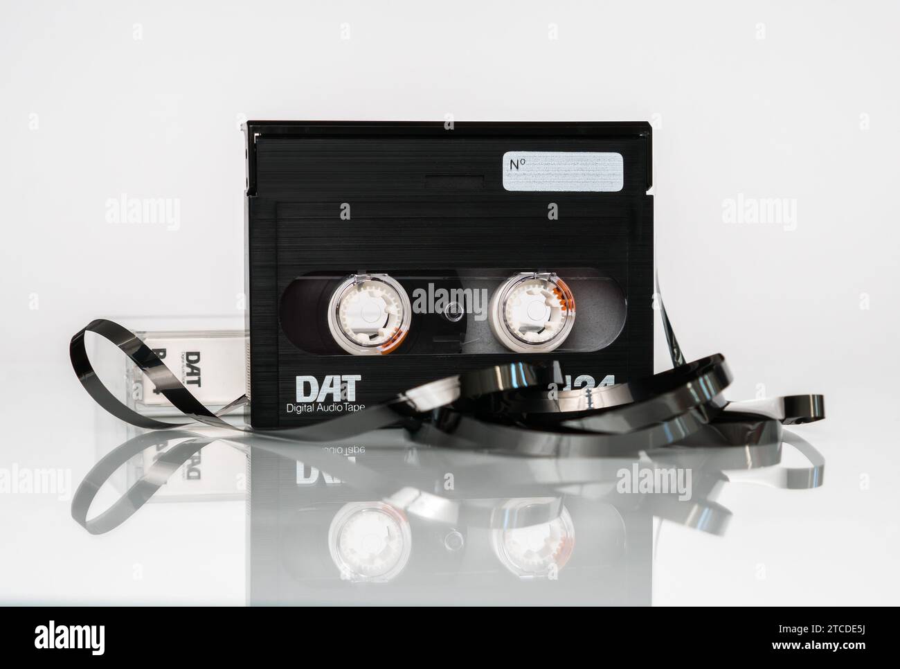 Front view of a DAT (digital audio cassette) cassette with a box and a twisted tape stands