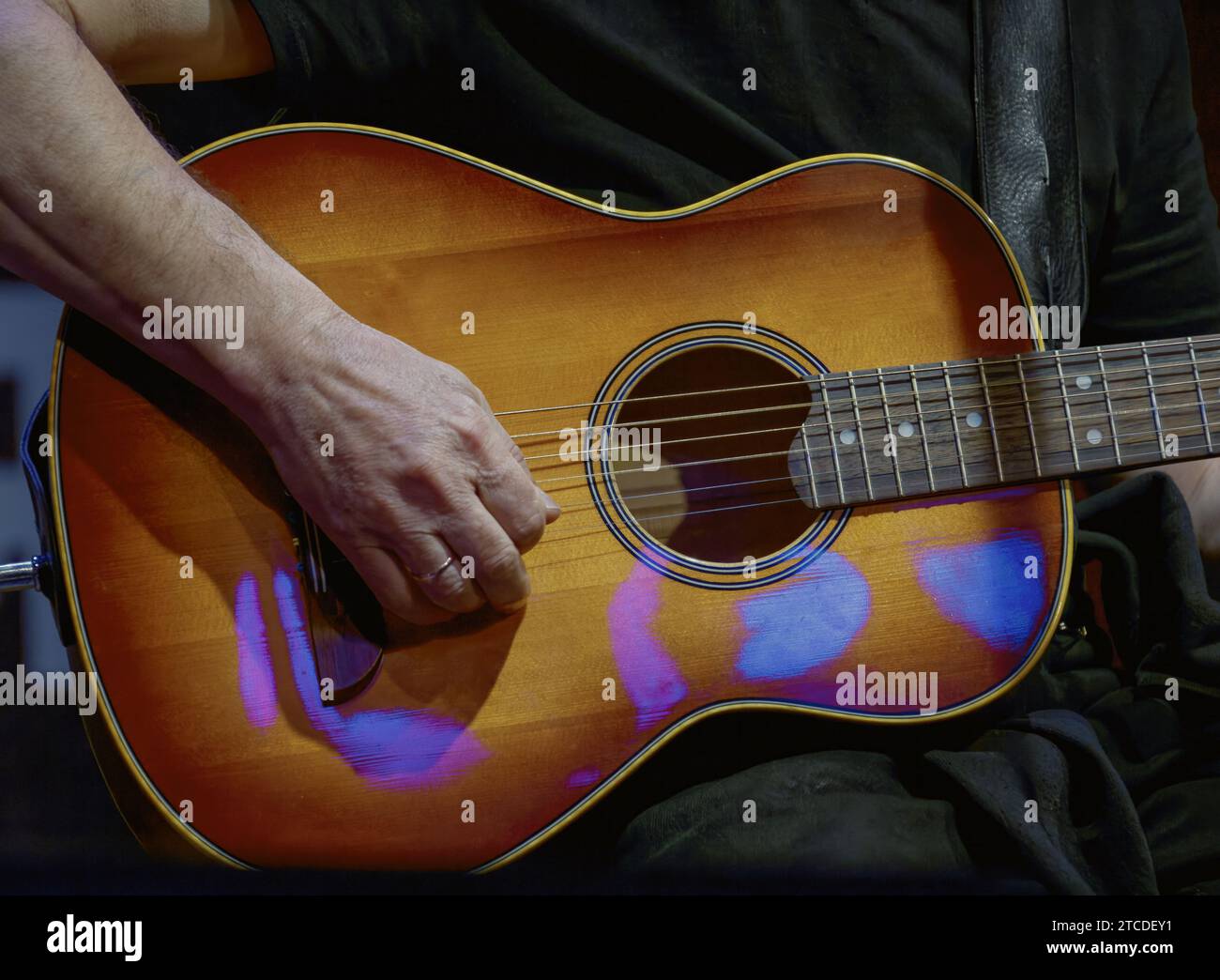 Image of a guitarist's hand playing on the strings of a guitar Stock Photo