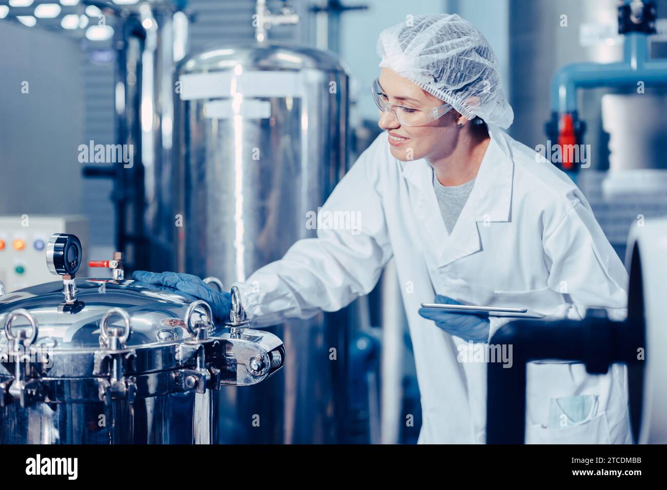 hygiene staff worker in foods and drinks clean factory. working women in water plant industry quality control check. Stock Photo