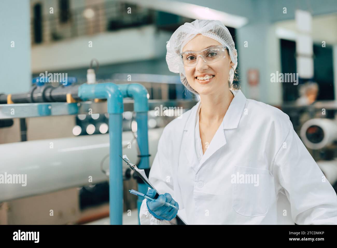 portrait happy women staff worker in drinking water plant work control water quality purification test process. Stock Photo