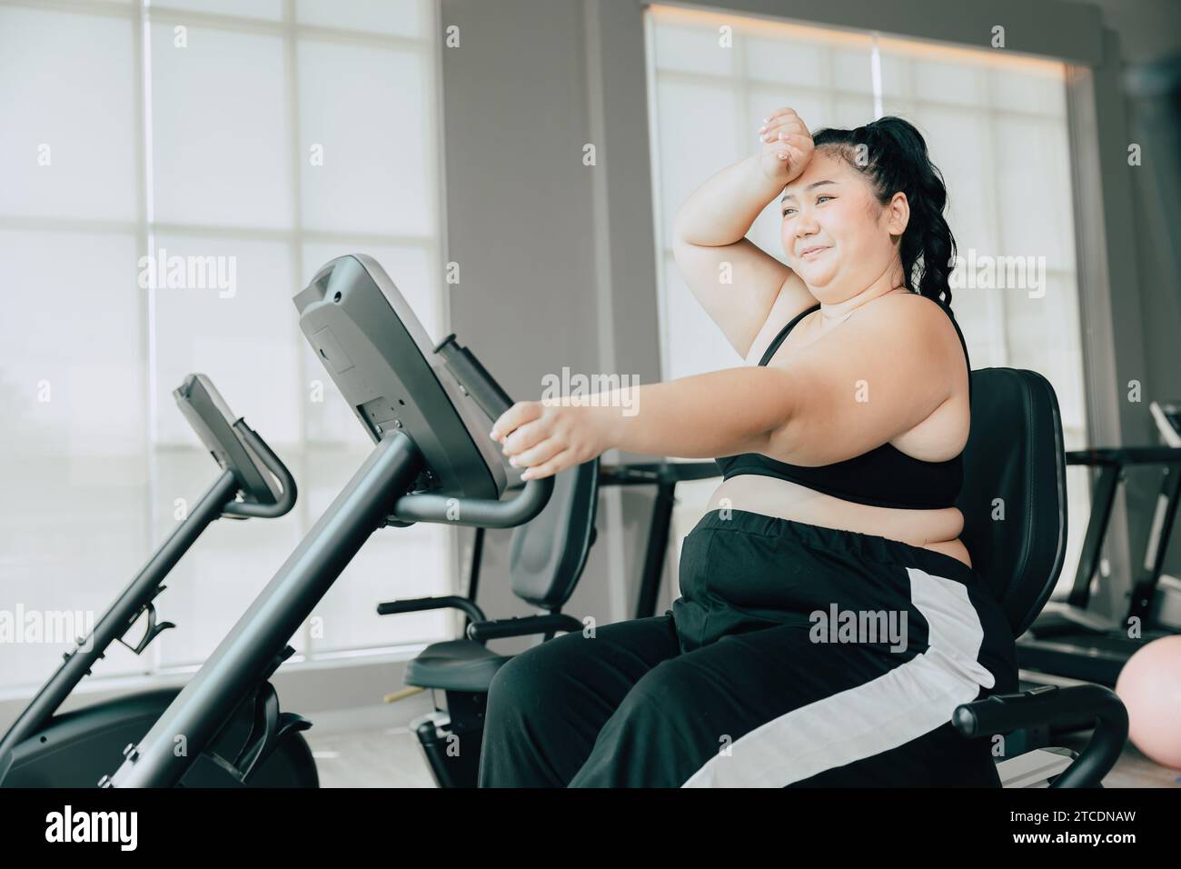 healthy fat women asian plus size lady doing workout exercise for lose weight body healthcare in sport club fitness Stock Photo