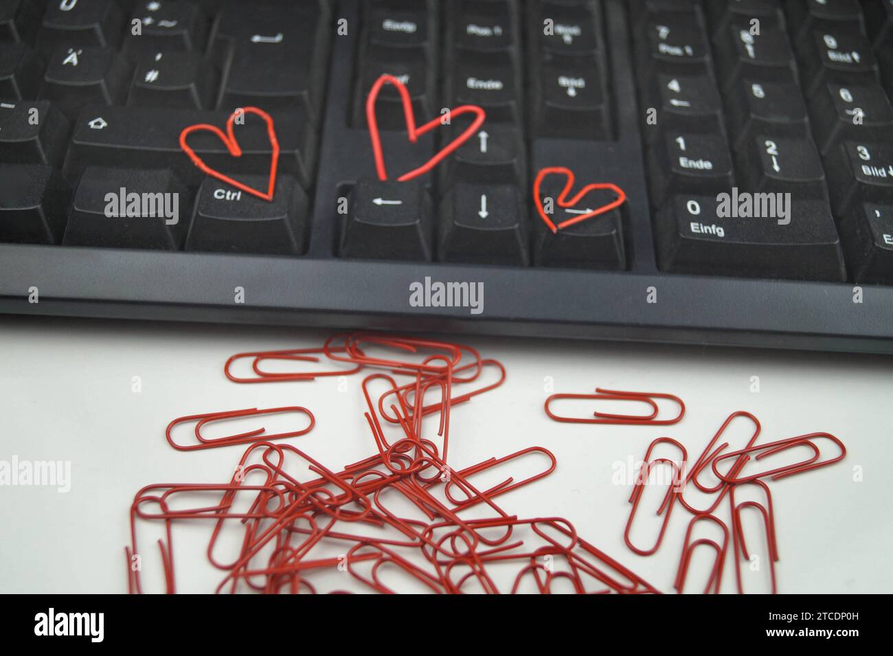 keypad with red paperclips, three of them heartshaped, love in the