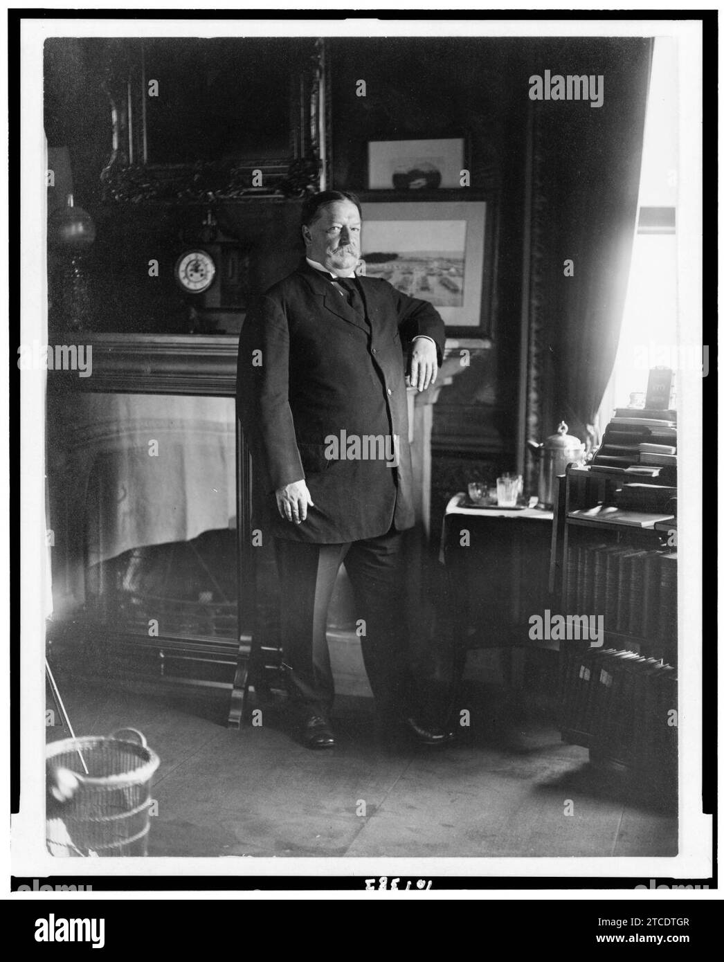 William H. Taft, fulllength portrait, standing by mantle facing right