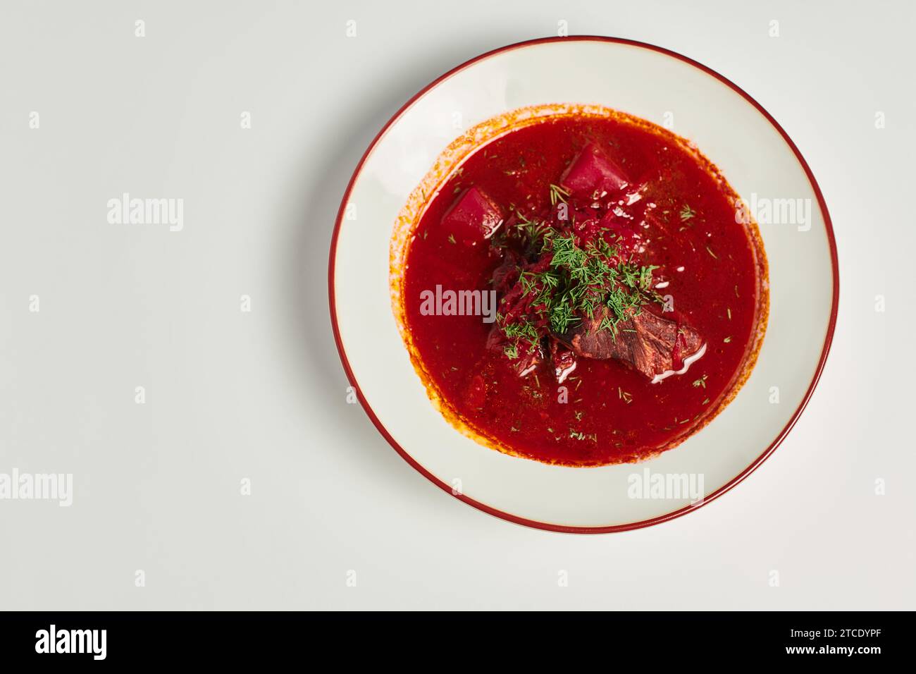 eastern European cuisine, traditional Ukrainian borsch with beef in ceramic bowl on grey backdrop Stock Photo