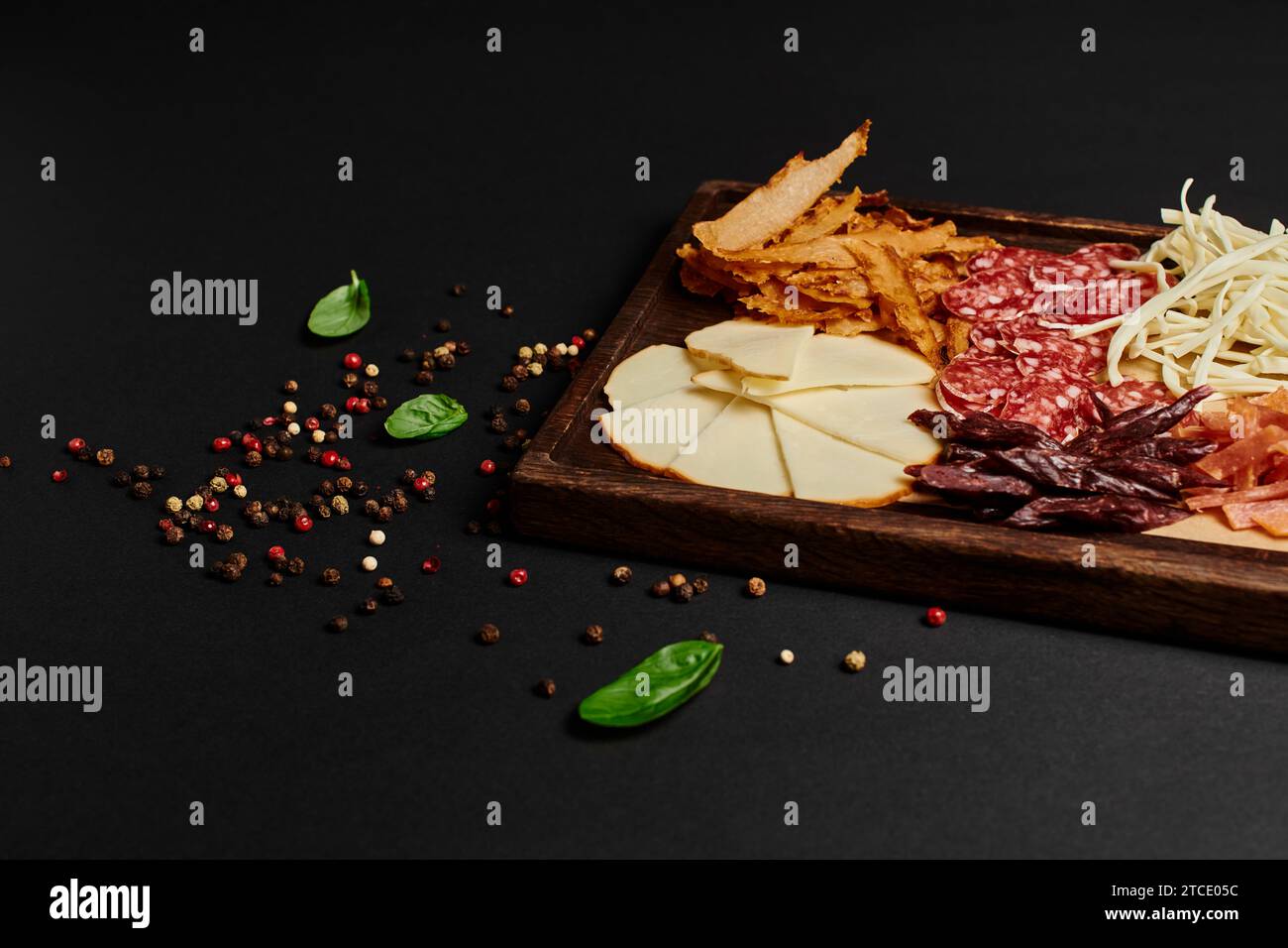 charcuterie board or party food with gourmet cheese selection, dried beef and salami slices on black Stock Photo