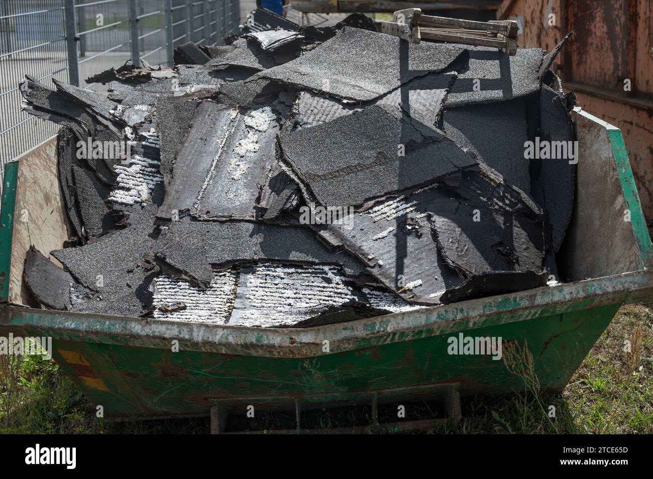 Asphalt felt placed in a construction waste container, demolition of the building in the