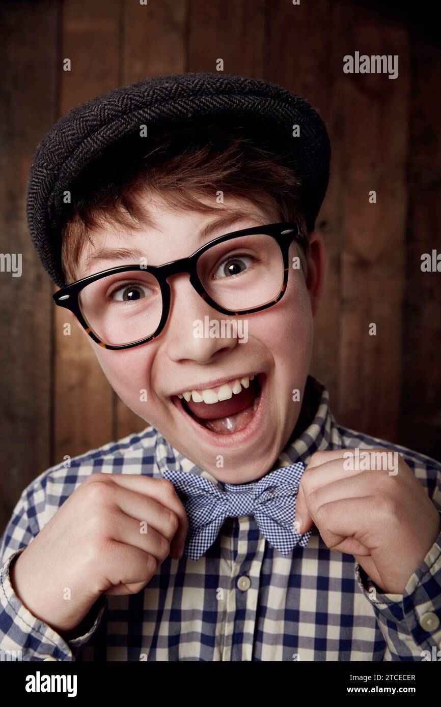 Portrait, glasses and excited kid with bow tie for fashion, retro or vintage. Happy face, nerd and smile of young boy child in hat, geek in stylish or Stock Photo