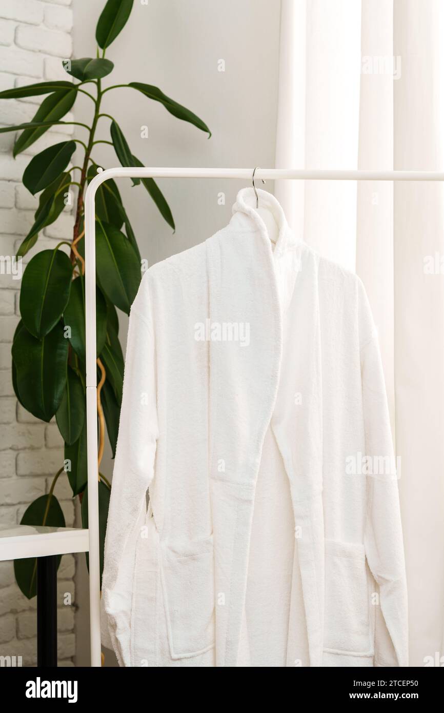 White robe on the rack in the bathroom Stock Photo - Alamy