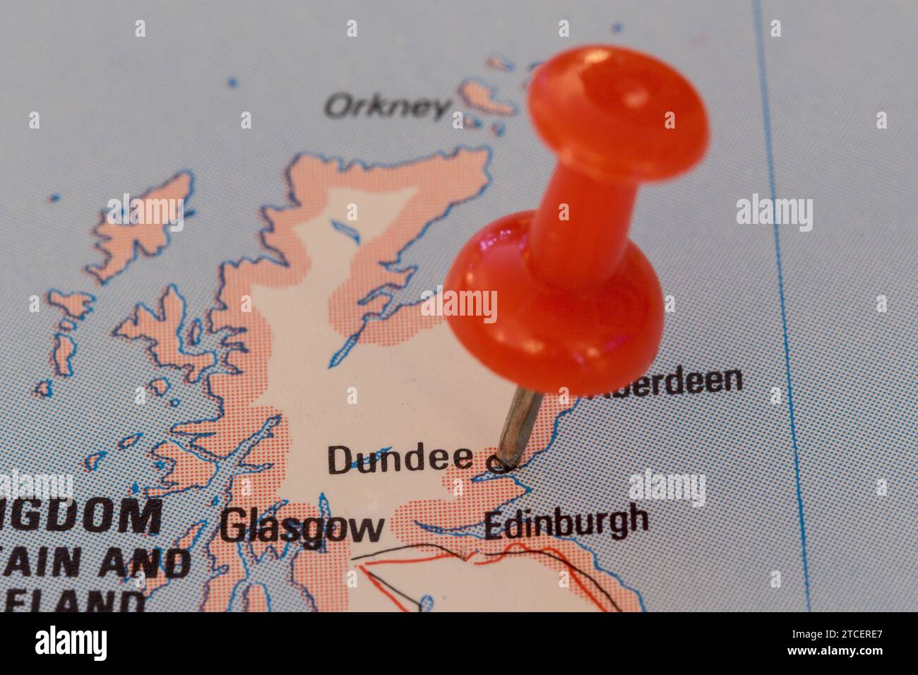 A red pin stuck into a map of Western Europe, pinpointing the location 