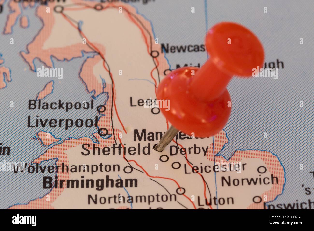 A red pin stuck into a map of Western Europe, pinpointing the location of Sheffield Stock Photo