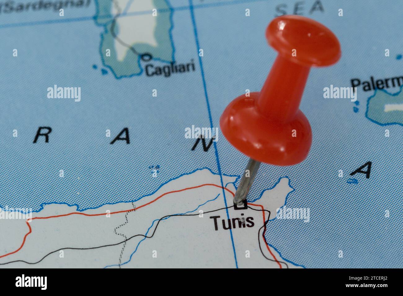 A red pin stuck into a map of Western Europe, pinpointing the location ...