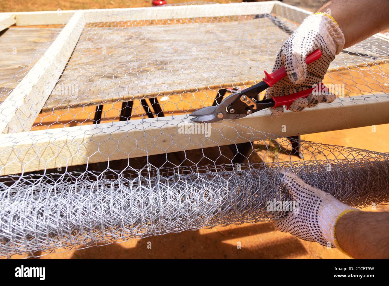 Worker uses scissors for metal to cut metal mesh Stock Photo Alamy