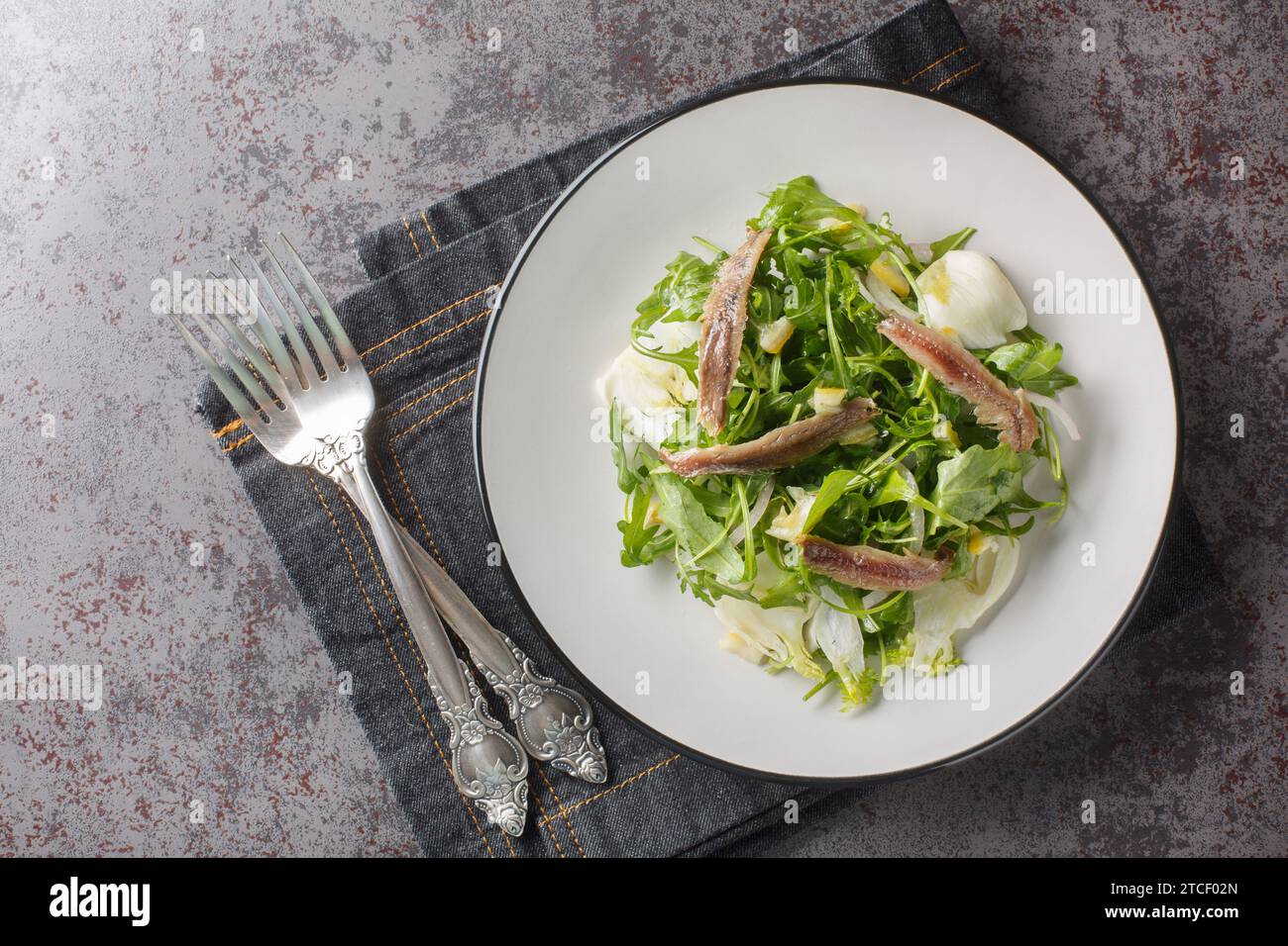 Serving of salad of arugula, fennel, anchovies, red onions and