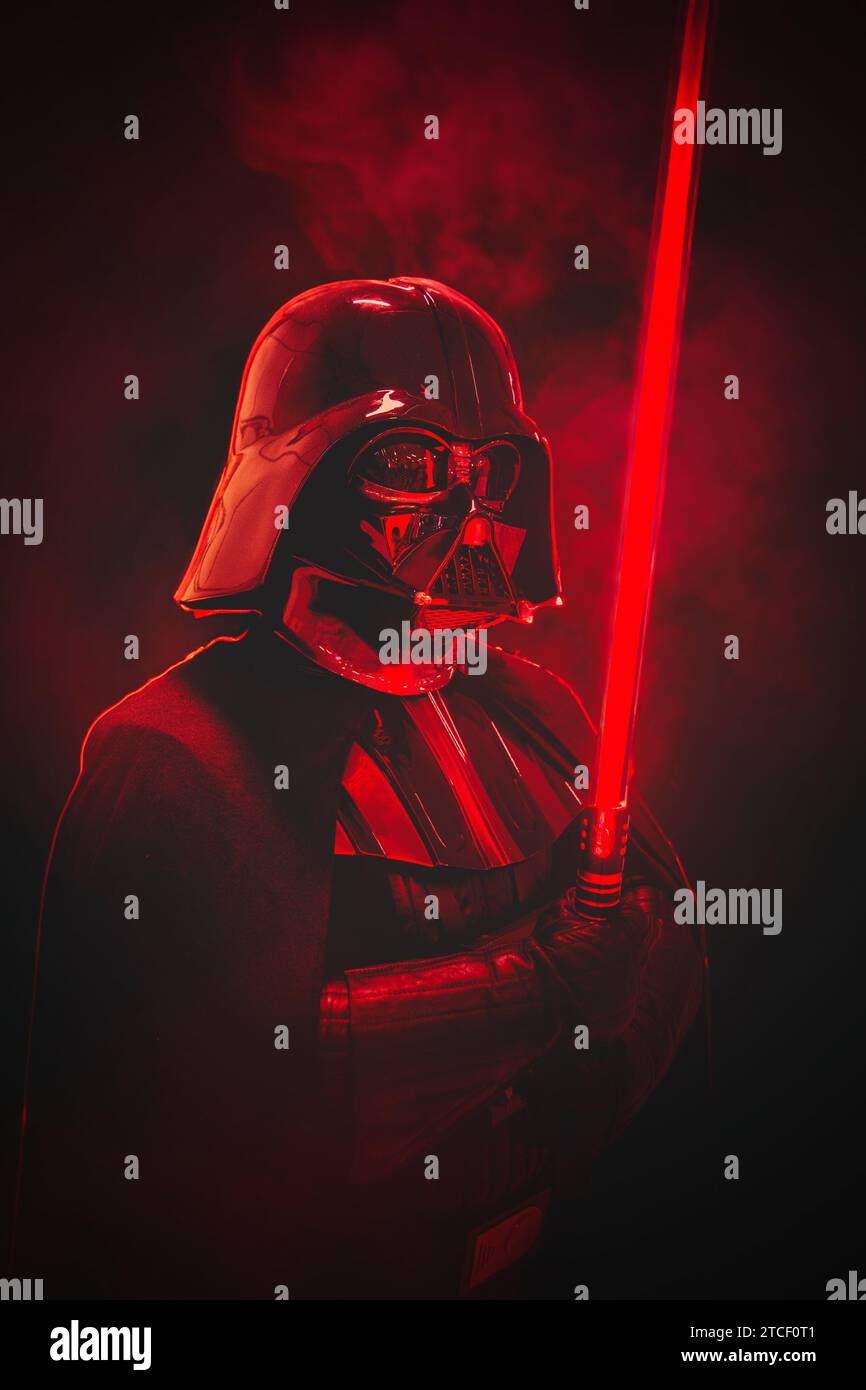 NEC, BIRMINGHAM, UK - DECEMBER 3, 2023.  A male cosplay at a comic con event in Darth Vader costume from Star Wars holding a red lightsaber in a drama Stock Photo