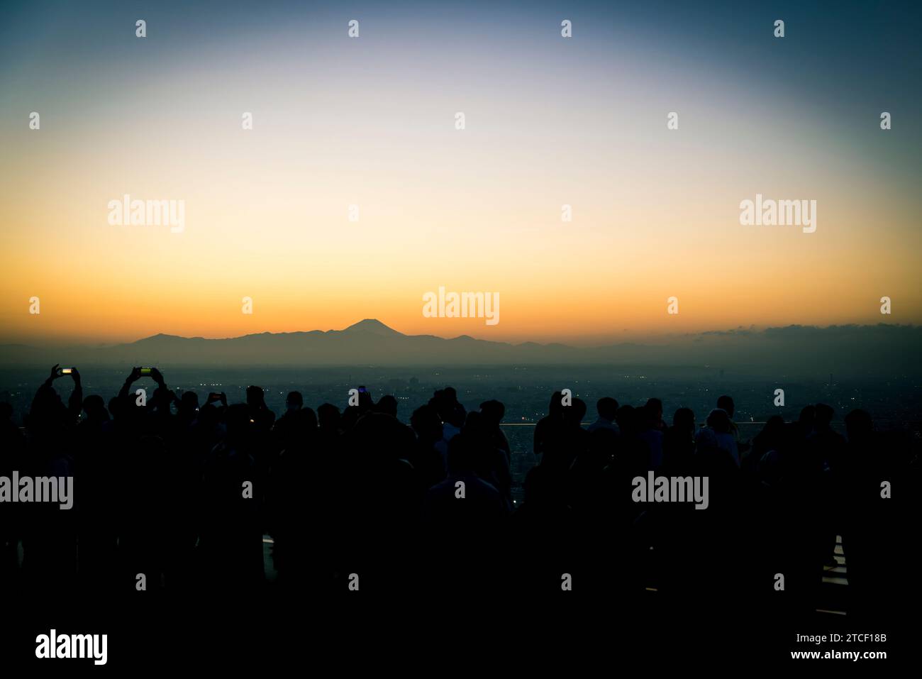 people wait for the sunset and photograph the city of Tokyo with Mount Fuji in the background Stock Photo