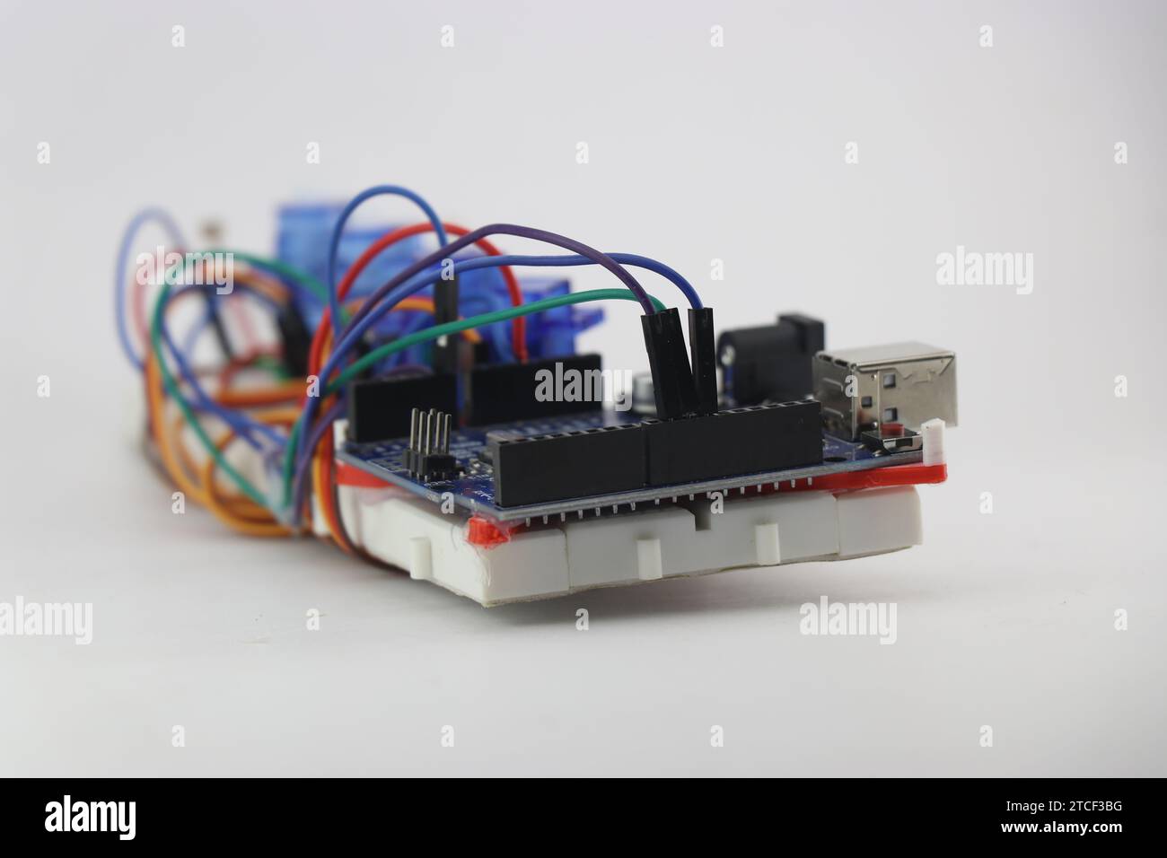 Micro controller board with jumper wires connecting breadboard and ...