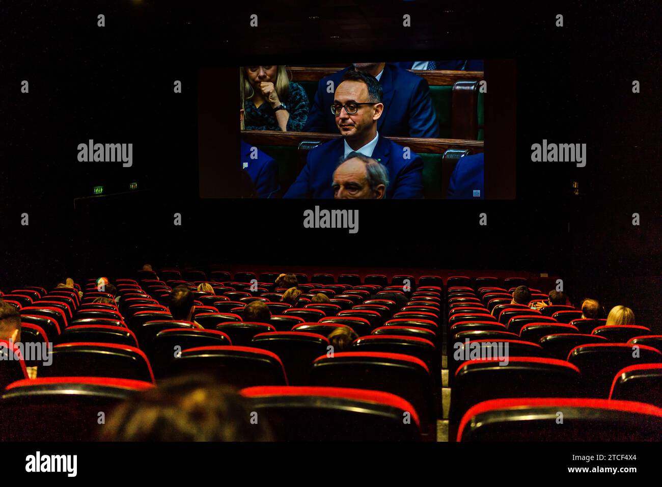 A cinema audience watches a live broadcast of the Polish Parliament proceedings, on the screen: Dariusz Klimczak PSL-TD receives a nomination for the office of Minister of Infrastructure Broadcast of the Sejm of the Republic of Poland in the Kinoteka cinema in Warsaw. After the victory of the Civic Coalition, the Left, the Third Way, and the defeat of Law and Justice, the Sejm channel on YouTube already has an audience of several million. Prime Minister Donald Tusk s Expose was broadcast in the cinema. Warsaw Poland Copyright: xMikolajxJaneczekx Stock Photo
