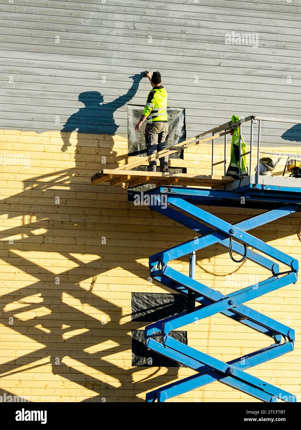 Residential house facade painting works after cladding with wooden