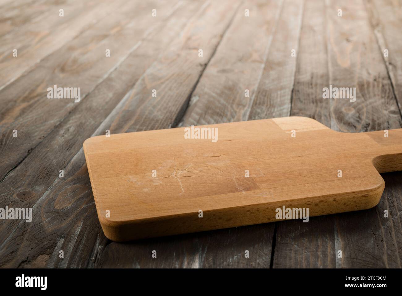 Wooden rectangular cutting board on rustic table. Stock Photo