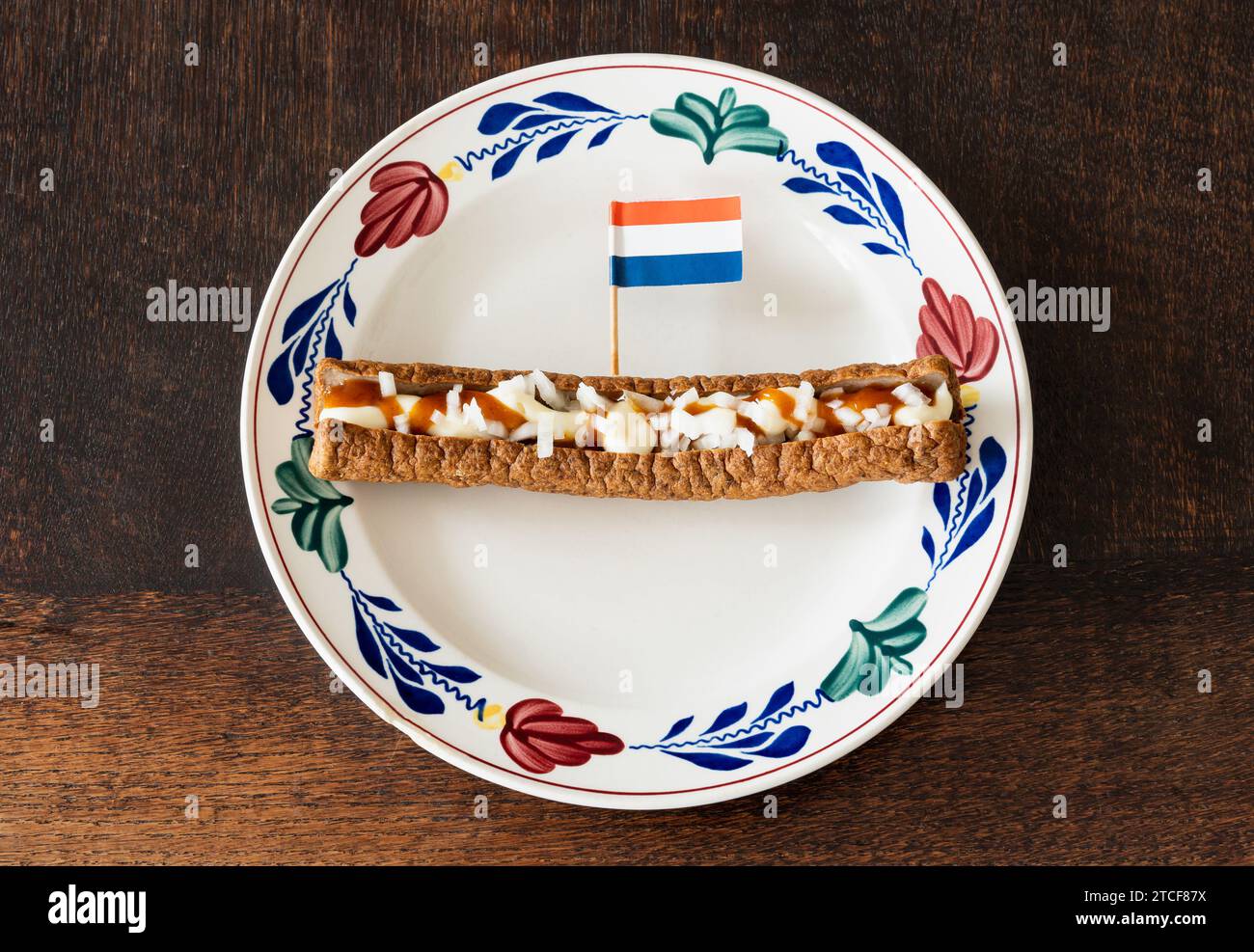 Frikandel speciaal, a traditional dutch fast food snack consisting of minced meat sausage, mayonnaise, curry and chopped raw onion Stock Photo