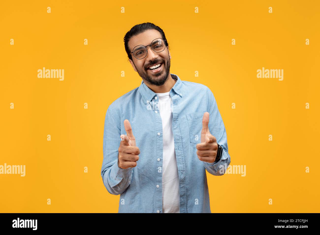 Welcoming man with glasses and a beard, pointing directly at the camera Stock Photo