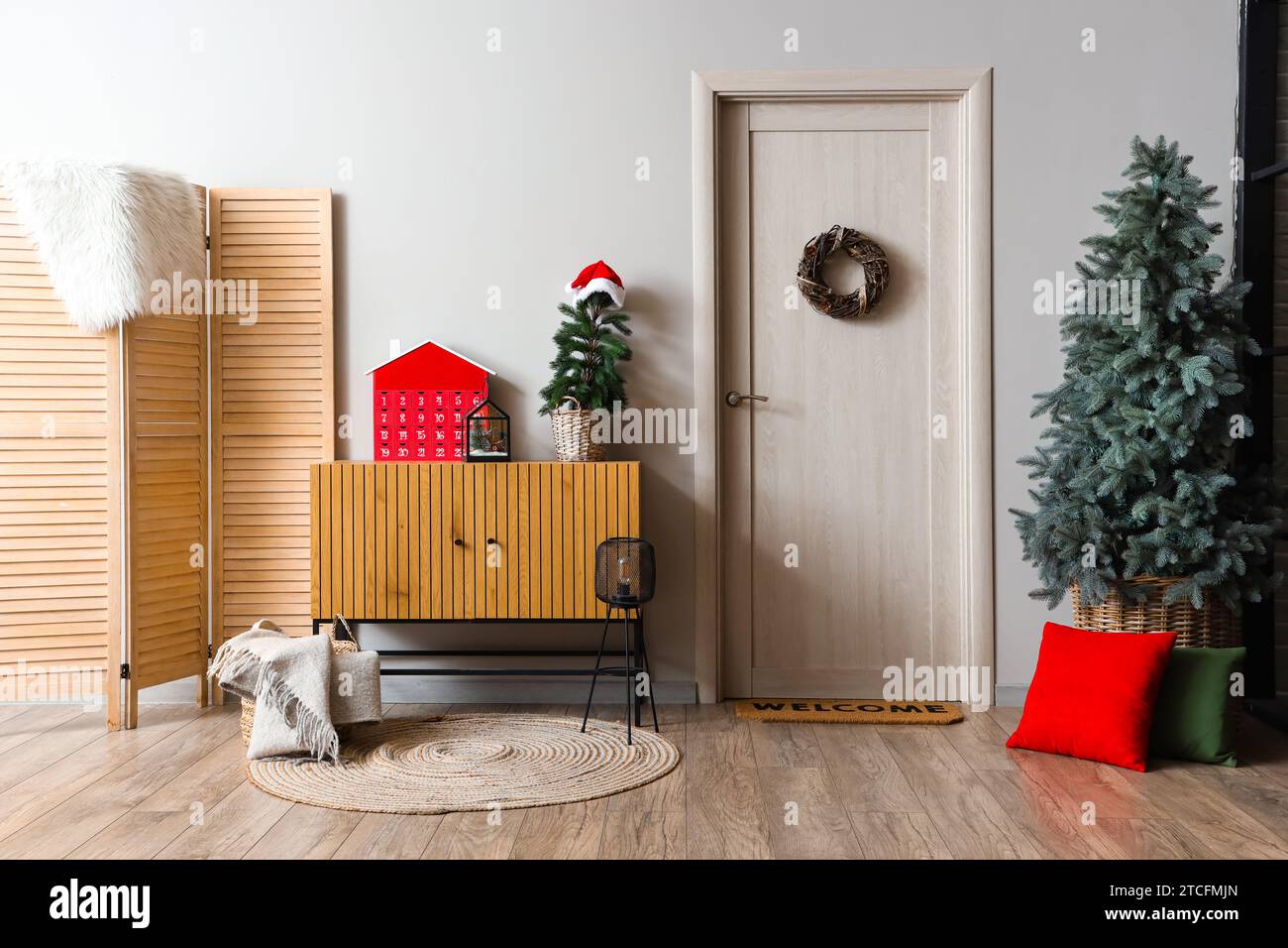 Interior of festive hallway with Christmas tree, wreath and wooden ...