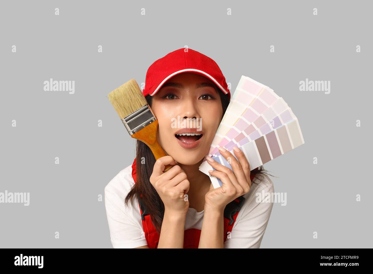 Female Asian painter with paint color palettes and brush on grey ...