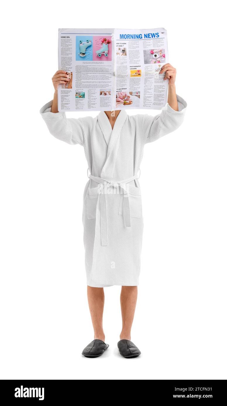 Teenage boy in bathrobe reading newspaper on white background Stock