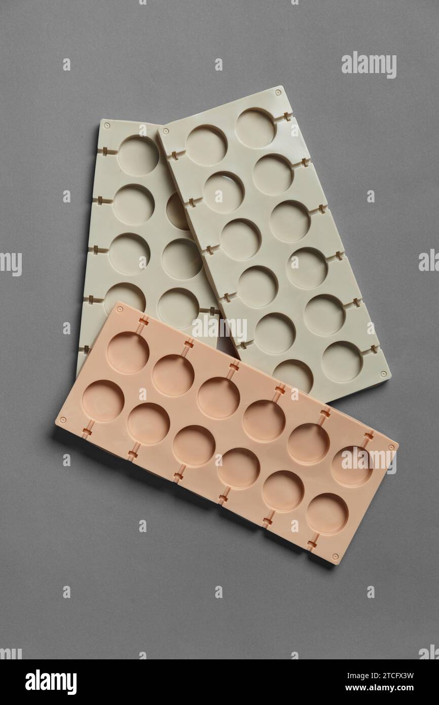 Silicone molds for making chocolates, lollipops, sweets on a gray
