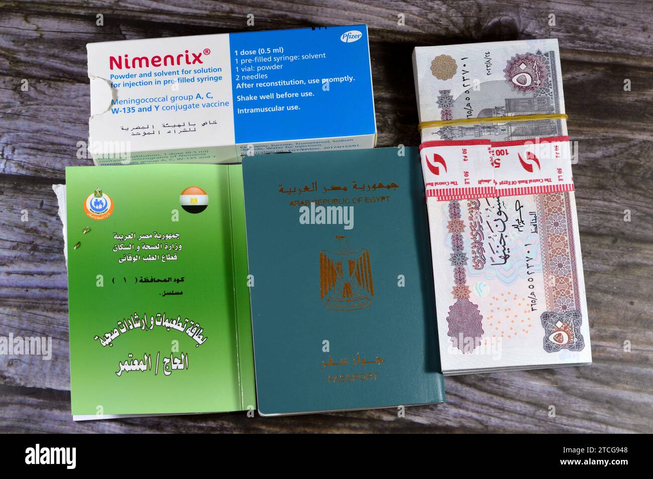 Cairo, Egypt, December 4 2023: Nimenrix vaccine, Egypt money, Egyptian passport and Vaccination card, health instruction from the preventive medicine Stock Photo