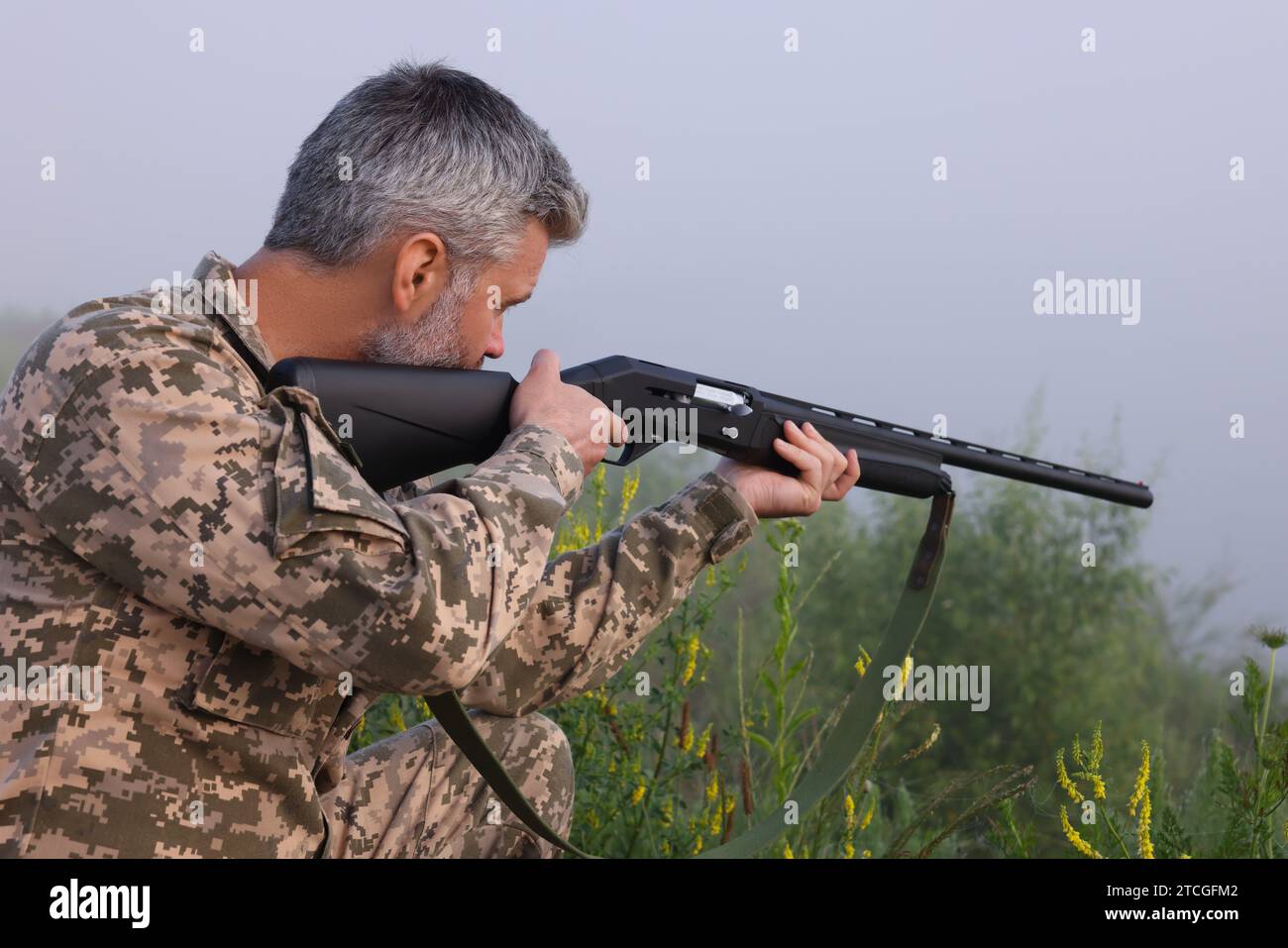 Man wearing camouflage and aiming with hunting rifle outdoors Stock ...
