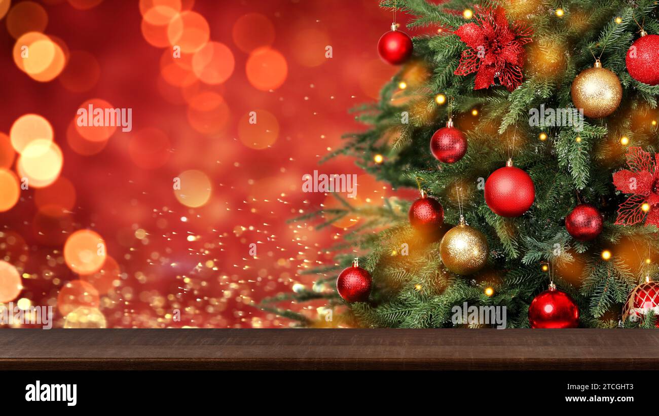 Christmas tree decorated with red and golden balls near wooden table ...