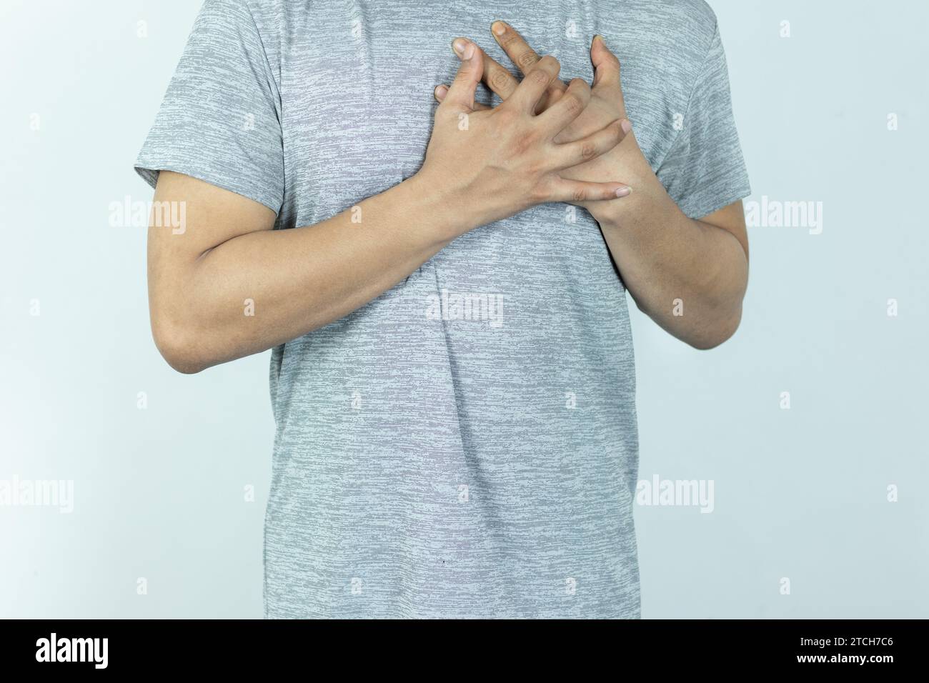 asian man pressing chest with painful expression. Severe heartache, having a heart attack or painful cramps, heart disease. Stock Photo