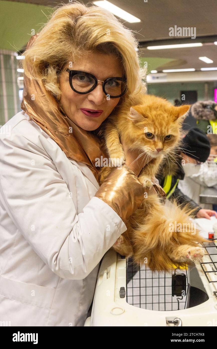 PRODUCTION - 02 December 2023, Hesse, Frankfurt/Main: Vet Maja Firlé holds Persian mongrel 'Mimi' in her arms in Frankfurt's Hauptwache subway station. The founder of the 'Tier-Not-Hilfe' association, Maja Firlé, and her colleagues treat animals free of charge for people who cannot afford to go to the vet. (to dpa-KORR Help for Mimi the cat - associations help with vet costs) Photo: Helmut Fricke/dpa Stock Photo