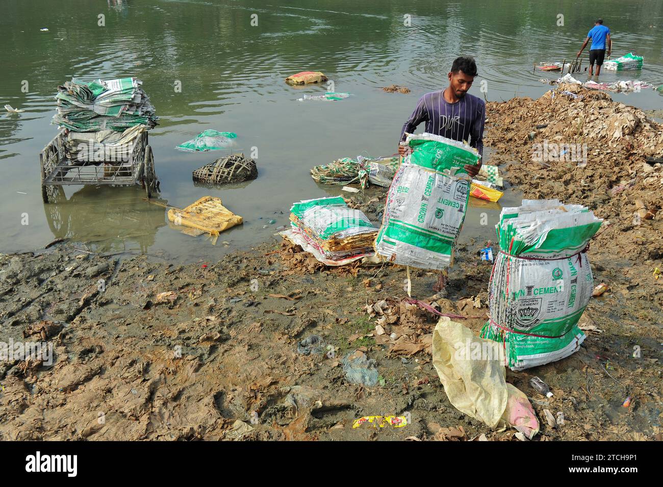 Women are risking their lives to wash cement bags beside the Surma