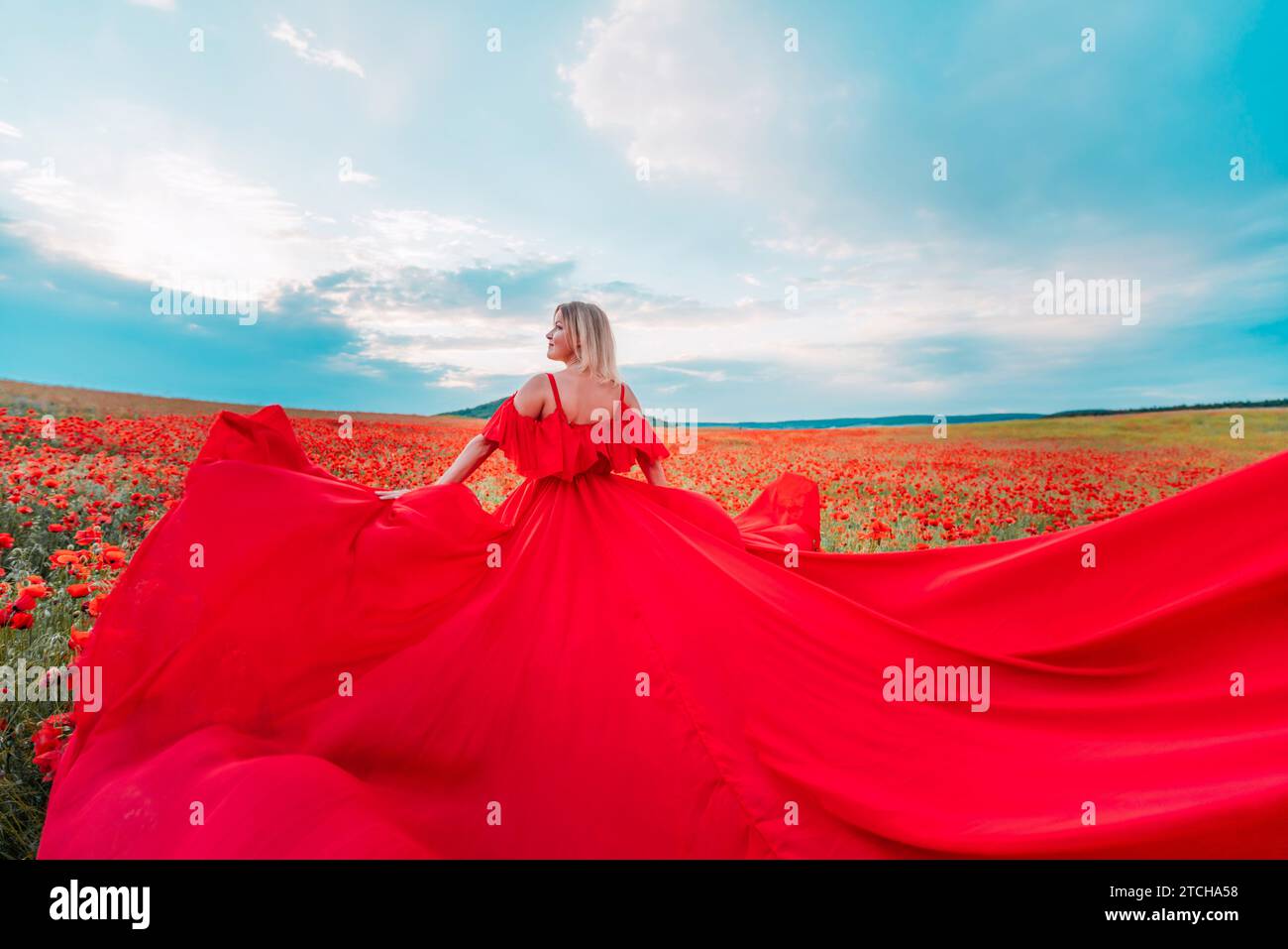 Woman poppy field red dress. Happy woman in a long red dress in a ...