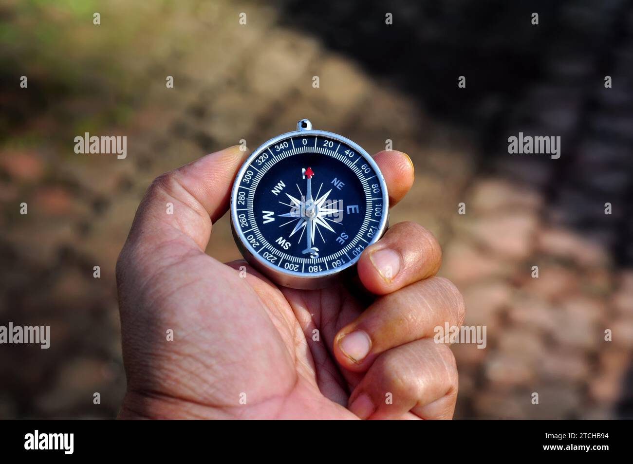 Hand holding a compass with blur background Stock Photo - Alamy