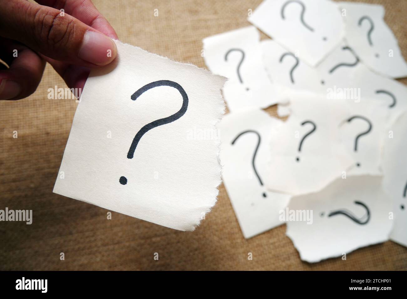 Torn paper showing question mark symbol on yellow background with copy ...