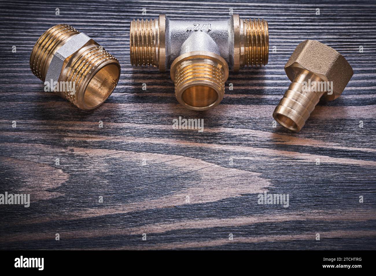 Brass equal T piece hose nipple safety valve on wooden background plumbing concept Stock Photo