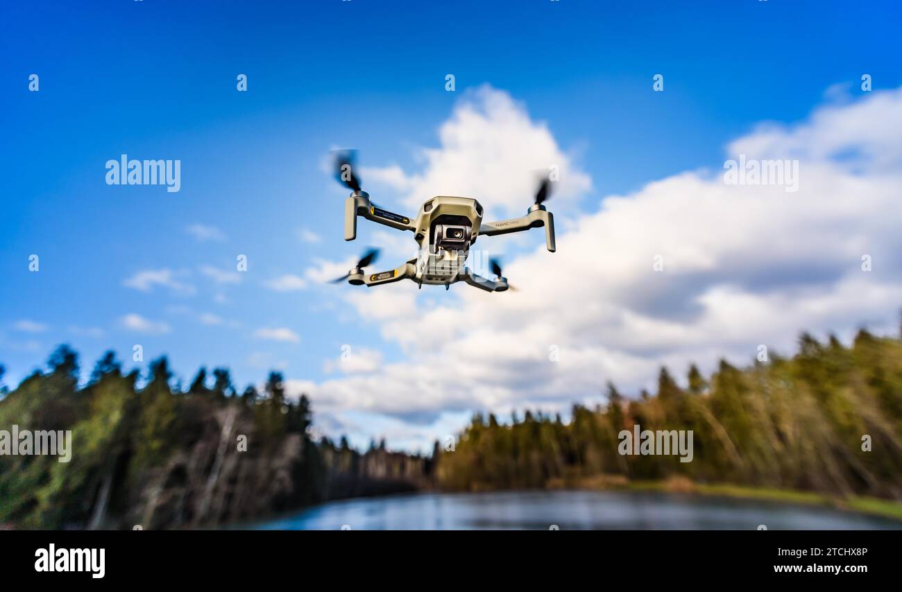 Graz, Austria, December 29 2019. DJI Mavic Mini drone flying in the countryside above frozen lake on sunny winter day. Drone flying Stock Photo