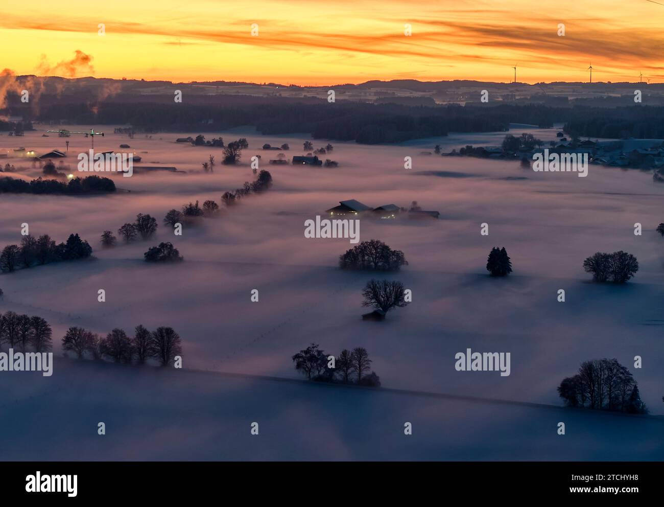 Drone photo of the Bavarian landscape with city view Ruderatshofen with fog in the evening short after sunset in Marktoberdorf, Germany, Dec 3, 2023.  © Peter Schatz / Alamy Stock Photos Stock Photo