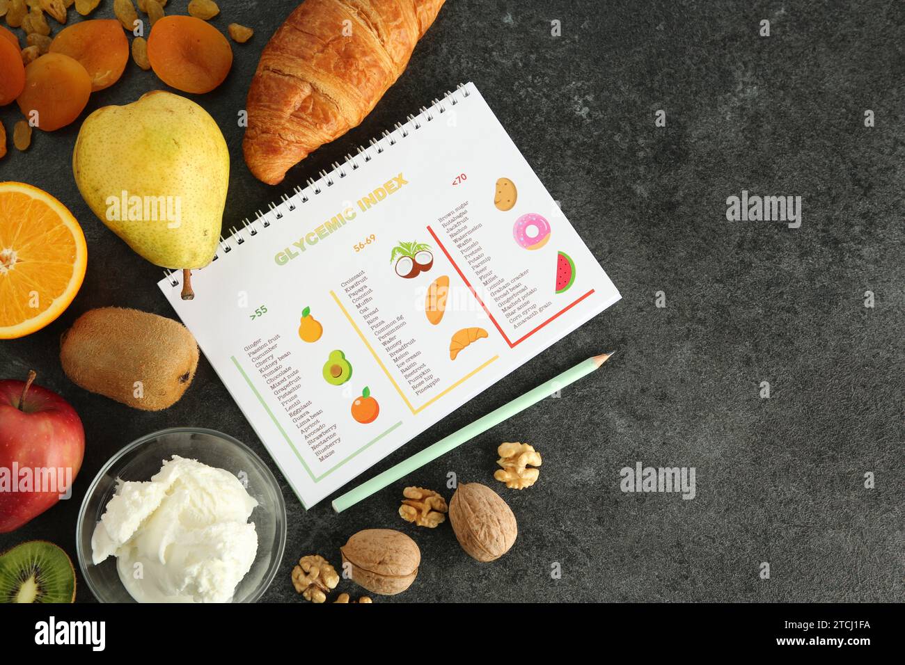 Notebook with glycemic index chart and products on grey table, flat lay. Space for text Stock Photo