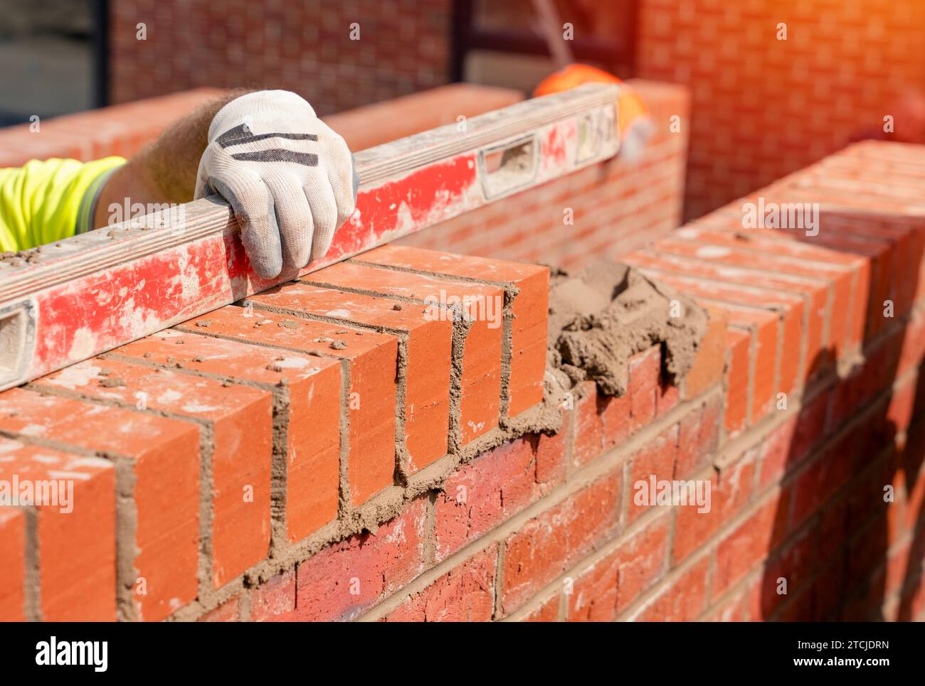 Bricklayers laying bricks on mortar Stock Photo Alamy