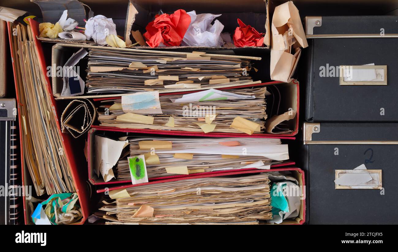 Row of messy file folders,old papers and boxes,red tape, bureaucracy,aministration,business concept Stock Photo