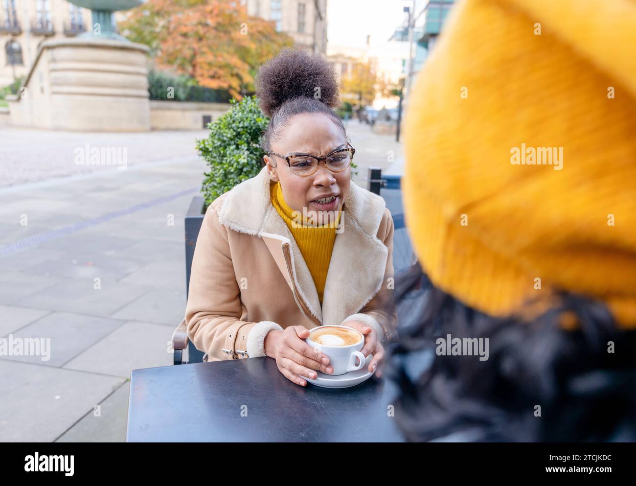 angry and unhappy woman in glasses  having an unpleasant conversation in a cafe Stock Photo