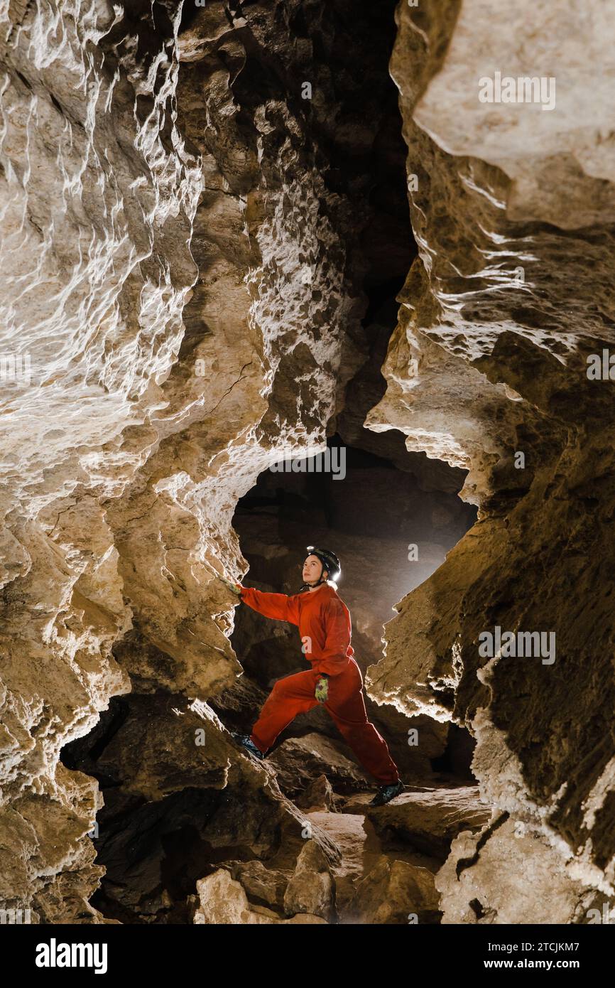 A portrait of a young female caver exploring the cave. Stock Photo