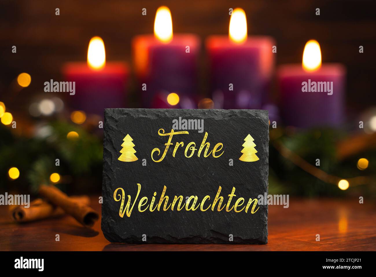 December 13, 2023: Greeting Merry Christmas on a sign in front of an Advent wreath with four burning candles PHOTOMONTAGE *** Gruß Frohe Weihnachten auf einem Schild vor einem Adventskranz mit vier brennenden Kerzen FOTOMONTAGE Stock Photo